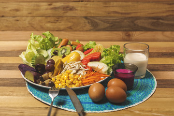 Salads ,eggs and milk placed on wooden table