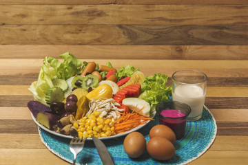Salads ,eggs and milk placed on wooden table