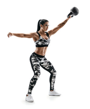 Strong athletic woman swinging a kettlebell. Photo of latin woman in fashionable sportswear isolated on white background. Strength and motivation. Full length