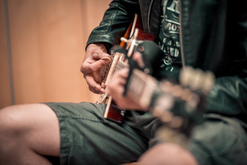 Junger Mann spielt Gitarre mit Plektrum