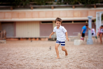 Sweet boy, playing on the beach, running happily