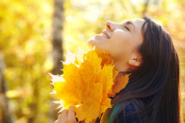 woman with yellow maple leaves in autumn