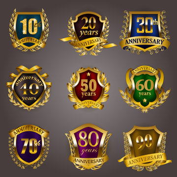 Set of gold anniversary badges with laurel wreaths, shield, numbers. Decorative emblem of jubilee on gray background. Filigree element, frame, border, icon, logo for web, page design in vintage style