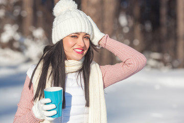Beautiful lady with coffee cup in winter time outdoors
