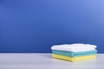 Microfiber cloths on blue background with copy space.