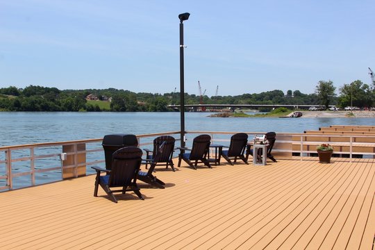 The Black Chairs On The Deck Of The Doc At The Lake.