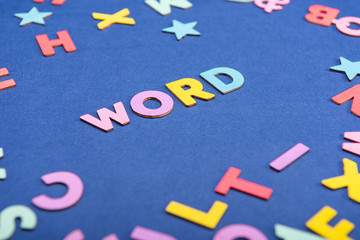Colorful "WORD" on mixed English alphabets background.