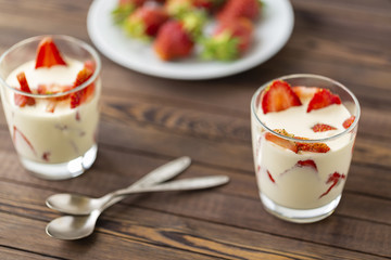 Closed up Yogurt in glass and strawberry on a wooden background. 
