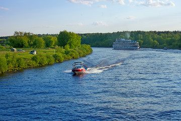 Fototapeta premium Landscape with Volga river, motor boat and cruise ship on a summer evening