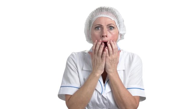 Attractive mature female doctor looking shocked. Medical middle aged female doctor shocked and surprised, white isolated background.