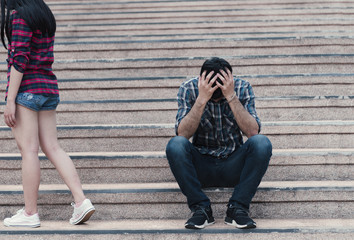 Teenager couple breaking up and ending relation after argument. Girlfriend legs leaves his sad...