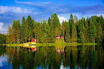 Summer cottage or log cabin by the blue lake in rural Finland.