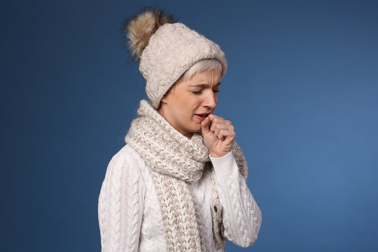 Frau mit Wintersachen hustet
