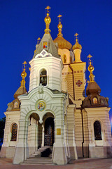 Fototapeta na wymiar Church with icons and golden domes with crosses against the background of a dark, blue evening sky