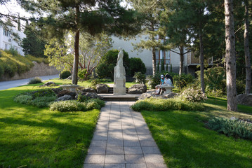 Obraz premium Holidaymakers are sitting on a bench in front of a beautiful decorative sculpture