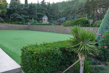 A field of shaved lawn grass for playing tennis in a park with beautiful landscape design