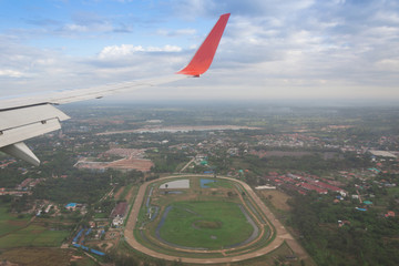 Wing of airplane flying above the city.