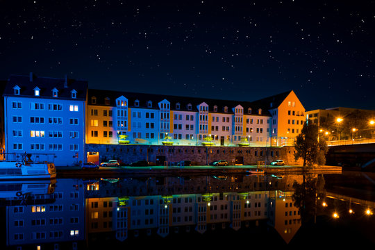 houses by the river in the city at night