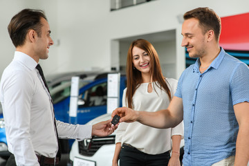 Obraz premium He takes new keys from his brandnew car