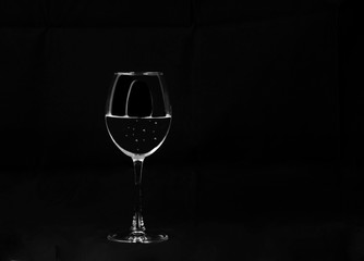 transparent glass on a long leg with water and gas bubbles on a 