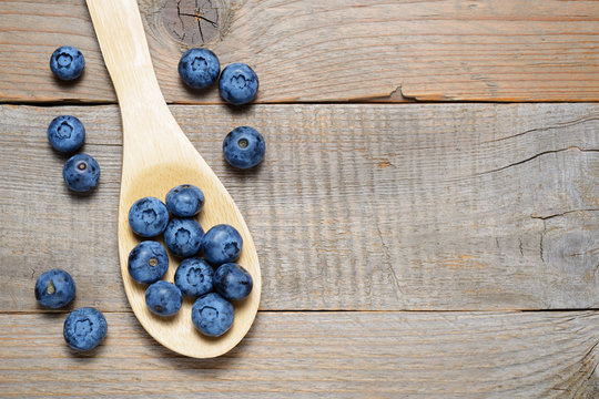 Blueberries in wooden spoon on table