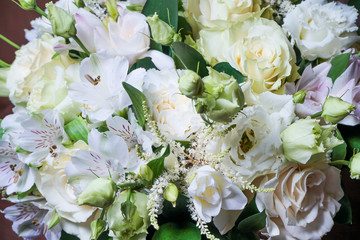 beautiful wedding bouquet with white roses and other flowers on wooden background  with 2 wooden pigeons