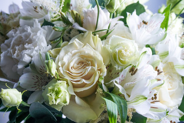 beautiful wedding bouquet with white roses and other flowers on wooden background  with 2 wooden pigeons