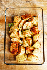 Raw potatoes in spices (chili, paprika, salt, peper) in glass vessel prepared to be roasted