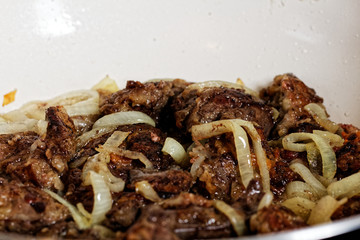 Chicken liver fried on a pan with onion