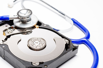 Close up computer hard disk and stethoscope data health check, data security concept on white...