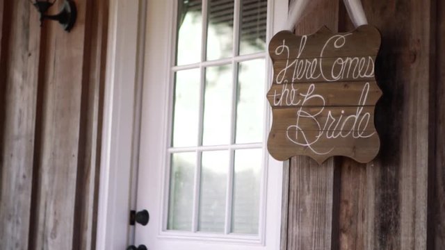 "Here comes the bride" sign hanging from doorway.