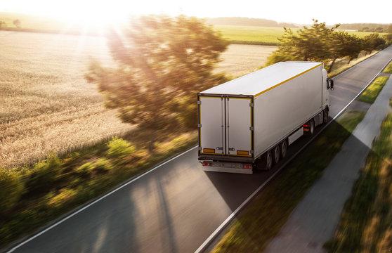 LKW bei Sonnenaufgang auf einer Landstra&szlig;e 