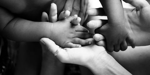 Touching moment, touch of the hand of a small child and an adult woman. Mother and child, adoptive children, adoption. A white woman and a dark skinned child. Interracial relations, multiracial family - 213489853