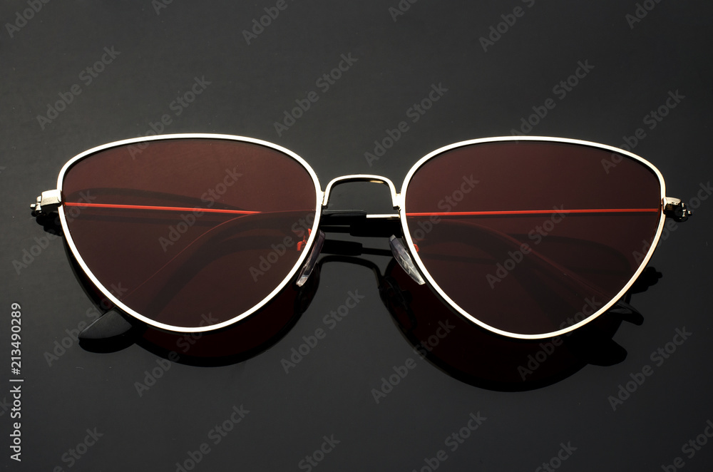 Poster sunglasses cat's eye with red glasses in metal frame isolated on black