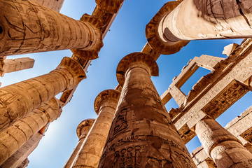 Ancient ruins and hieroglyphs at Karnak Temple, Luxor, Egypt. View from the ground to the high...