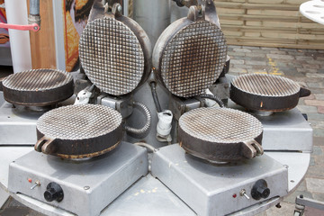 several devices to make waffles in an outdoor funfair