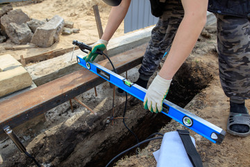 The worker measures the length at the construction site