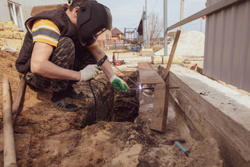 Worker welds metal at the construction site