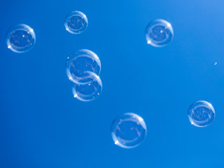 Soap bubbles in flight against the blue sky