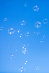 Soap bubbles in flight against the blue sky