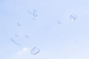 Soap bubbles in flight against the blue sky