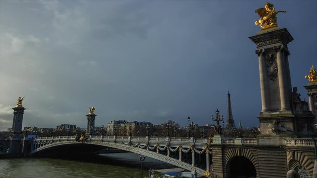Time lapse of Paris cityscape with the Seine river, bridge Alexandre III and Eiffel tower on a cloudy day. Urban transportation, tourism concept. Famous touristic places and landmarks in France