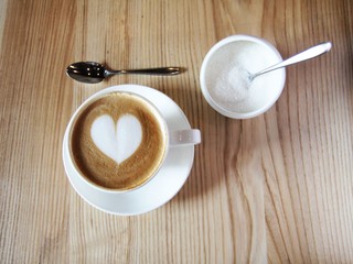 Cappuccino with heart decoration and sugar bowl