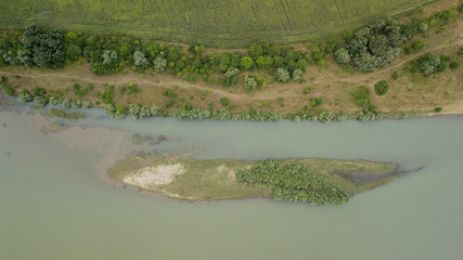 Aerial top view of summer green trees, river, roads in forest background. Drone photography. Coniferous and deciduous trees, forest road. Beautiful panoramic photo over the tops of pine forest.