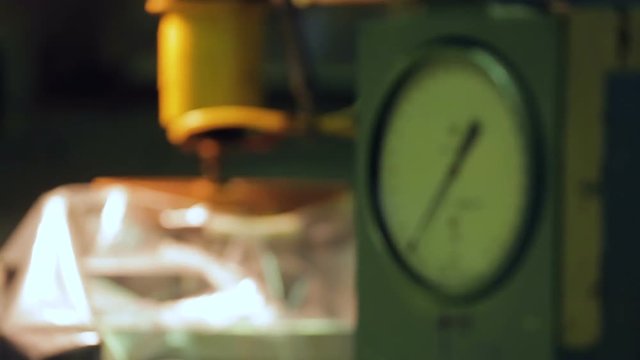 The industrial grinding machine against the background of a manometer in the production. Close up view