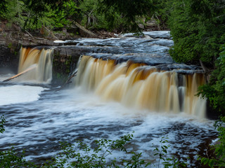 Fototapeta na wymiar Waterfall in woods close-up horizontal