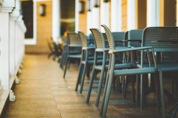 close up photo of the line of modern and comfortable tables and chairs in the restaurant balcony with classic white fence
