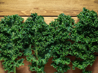 Raw organic freshly picked green curly kale on wooden table