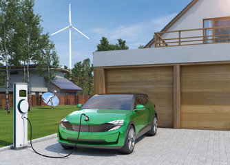 Elektroauto SUV in grün tankt Strom zu Hause mit Windrad im Hintergrund