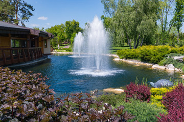 View of an ornamental lake with two beating fountains and beautiful flower beds on the sides
